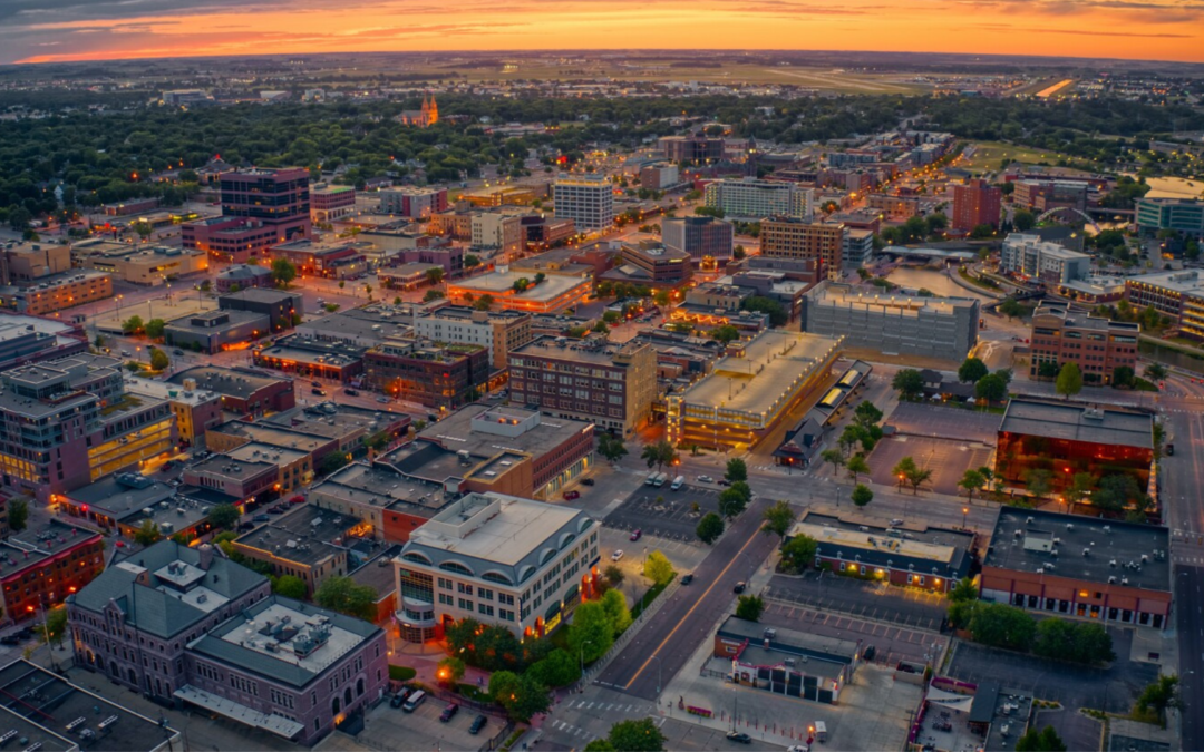 First-time homebuyer contemplating Sioux Falls housing market with city skyline in the background