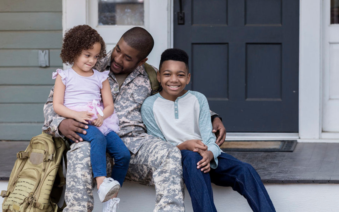 Veteran holding keys in front of new home with American flag in Sioux Falls